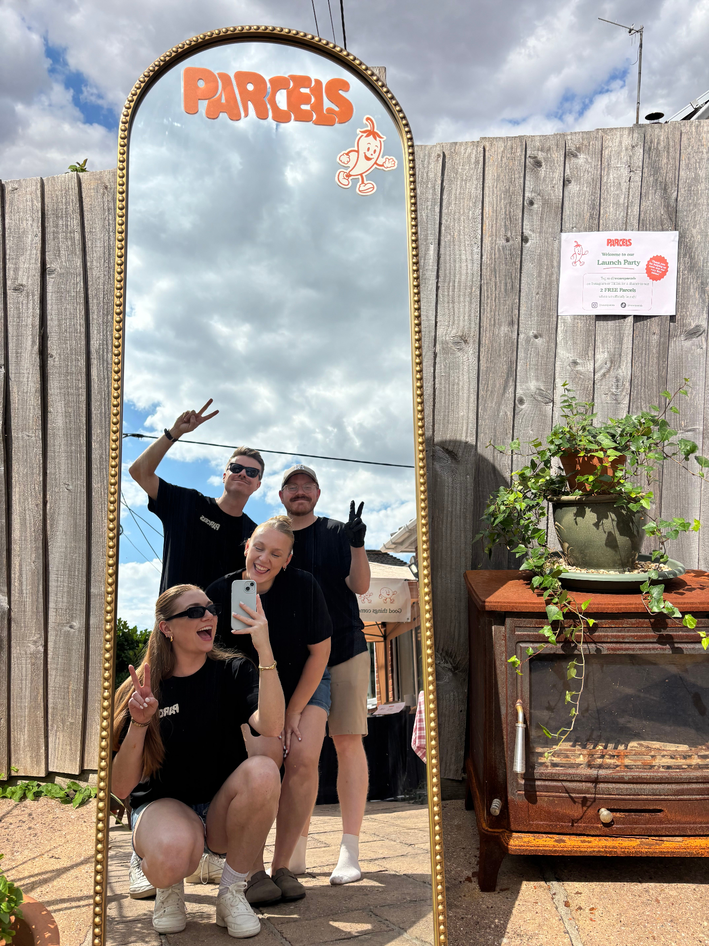 The Parcels team posing in a mirror at the launch party
