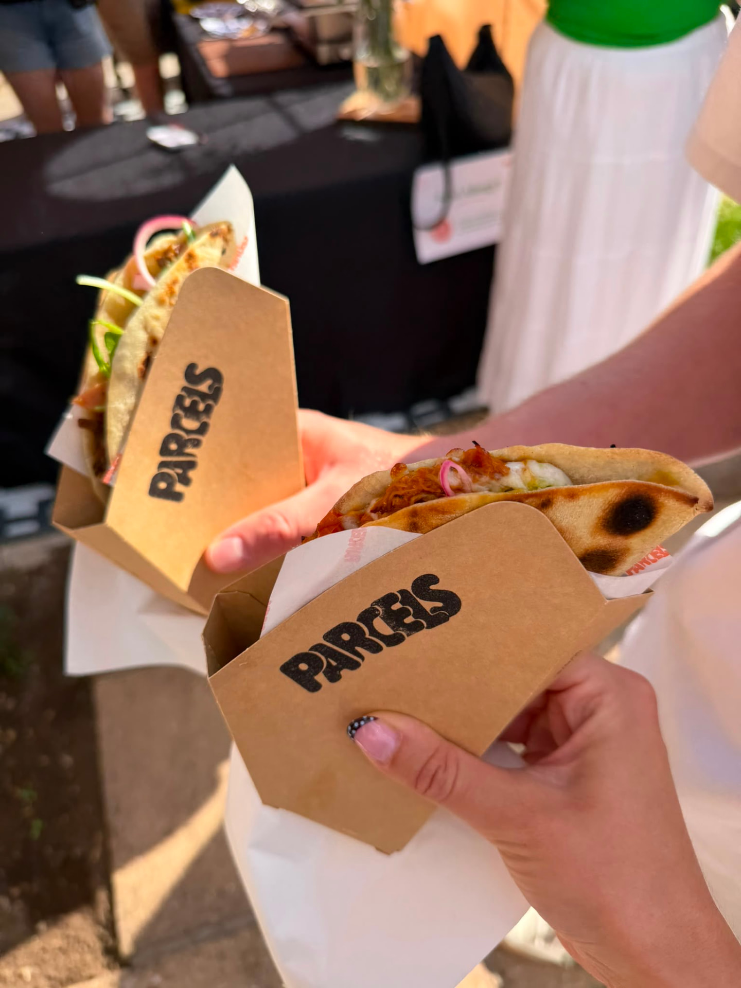 Guests holding Parcels boxes filled with freshly griddled parcels